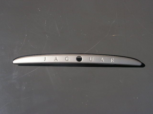 Jaguar XKR/8 afwerkstrip met Jaguar-logo in kleur gespoten. GEBRUIKT